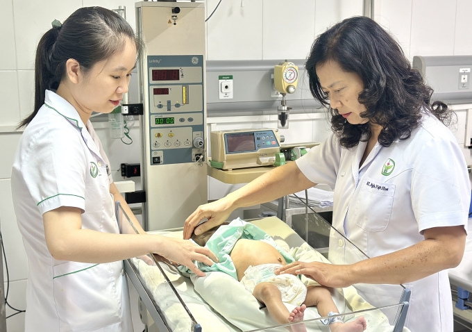 Bác sĩ Hoa (phải) thăm khám cho một bệnh nhi. Ảnh: Thái Ngọc