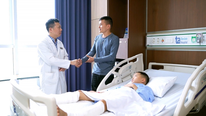 Bác sĩ Nghĩa khám cho bé Doanh sau phẫu thuật. Ảnh: Bệnh viện Đa khoa Tâm Anh